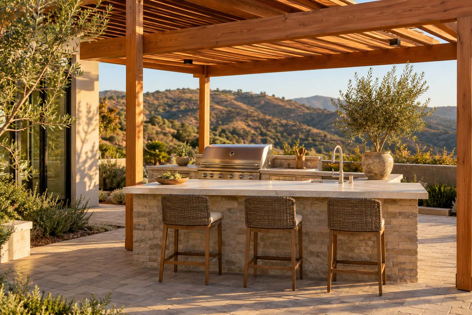 Outdoor kitchen island with a built-in grill and stone countertop under a cedar pergola